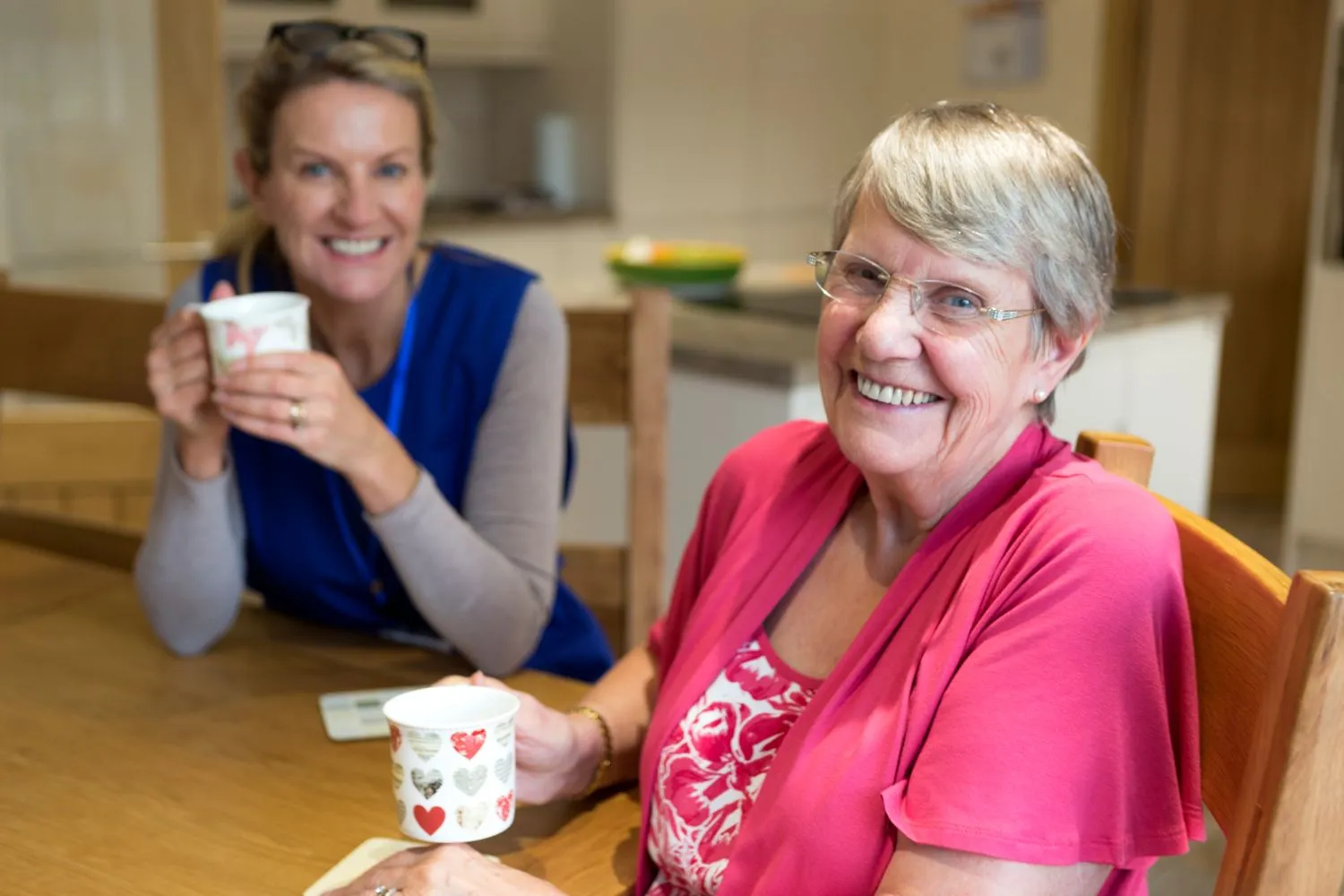 Senior lady having cup of tea with Care worker